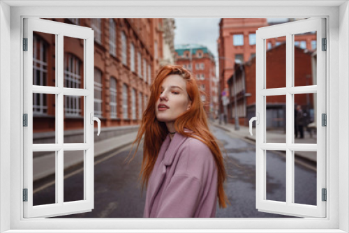 Portrait of beautiful redhair woman walking the city park.