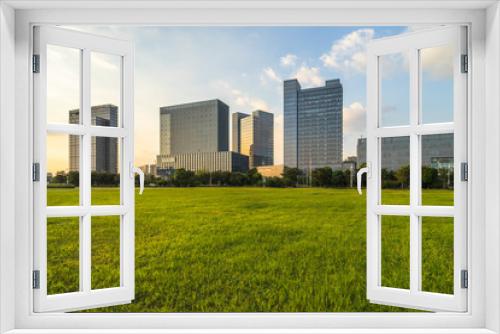 cityscape and skyline of suzhou from meadow in park