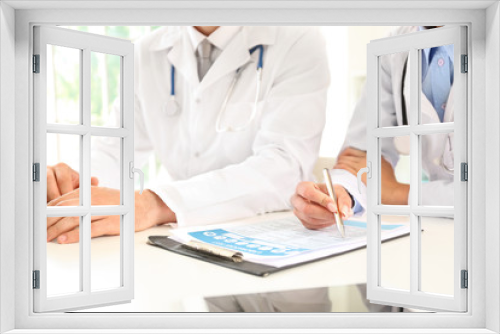 Fototapeta Naklejka Na Ścianę Okno 3D - Male and female doctors working at table in clinic