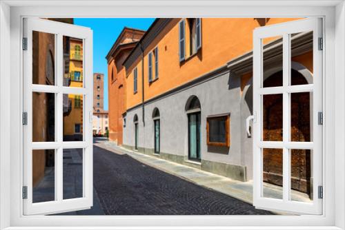 Fototapeta Naklejka Na Ścianę Okno 3D - Narrow,cobblestone street among old colorful houses in Alba, Italy.