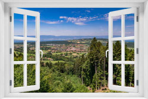 Fototapeta Naklejka Na Ścianę Okno 3D -  City landscape in the mountains, hills, fields, forests, green meadows, lakes in the distance and blue sky with clouds,focus area in the city.Town Bons-en-Chablais, Haute-Savoie in France.