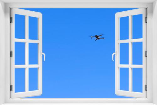 Fototapeta Naklejka Na Ścianę Okno 3D - Black drone quadcopter flying on the air for take a photo and video with blue sky background.
