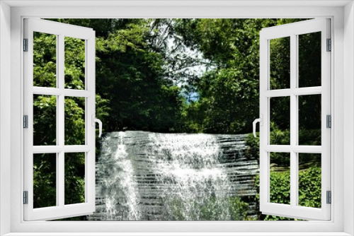 Fototapeta Naklejka Na Ścianę Okno 3D - Water fall surrounded by green foliage 