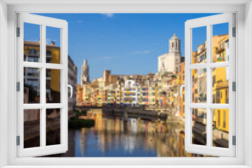 Fototapeta Naklejka Na Ścianę Okno 3D - Girona's tipical skyline cityscape over the Onyar River with colourful river houses on a blue sunny sky, Church of Sant Feliu Cathedral landmark on background
