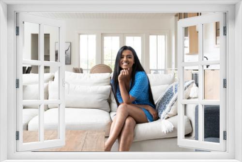 Woman of color hanging out at a brightly lit luxury beach house