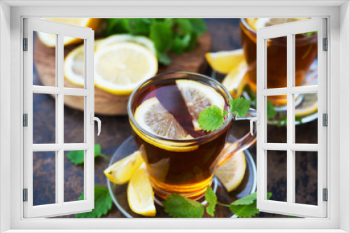 Fototapeta Naklejka Na Ścianę Okno 3D - Black hot tea with lemon and mint. Warming autumn revitalizing drink.