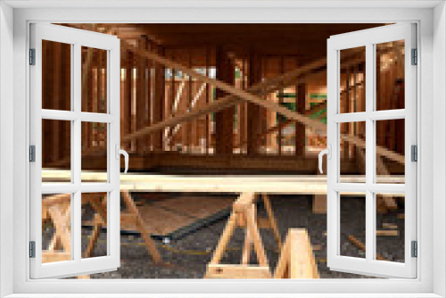 Fototapeta Naklejka Na Ścianę Okno 3D - New Home Under Construction with Lumber Framing and Carpentry Builders Craftsman