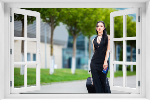 Young Cheerful Woman With a Suitcase. The Concept of Travel and work