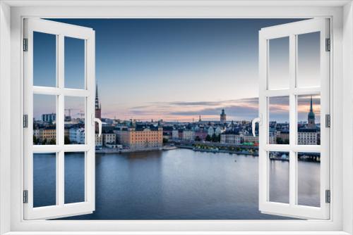 Fototapeta Naklejka Na Ścianę Okno 3D - A colorful sunrise over Stockholm with the lights reflecting on the calm water of the sea - 8