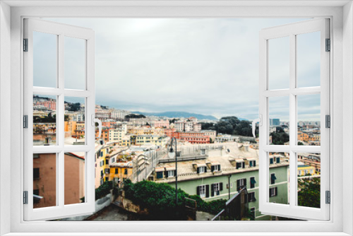 Fototapeta Naklejka Na Ścianę Okno 3D - Many beautiful old italian houses painted in bright colors with mountains on the background.An amazing cityscape of some public housing in Genova built in the 60s over hills of the city in cloudy day,