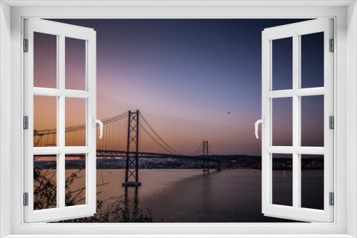 Fototapeta Naklejka Na Ścianę Okno 3D - The 25 de April Bridge in Sunset Lights. Amazing view on Tagus River and one of the most famous and popular tourist sights in Lisbon. Portugal's beautiful landmark