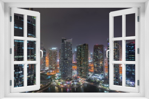 Fototapeta Naklejka Na Ścianę Okno 3D - Residential and office buildings in Jumeirah lake towers district night timelapse in Dubai