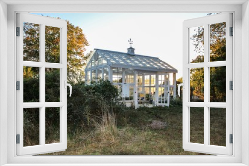 Fototapeta Naklejka Na Ścianę Okno 3D - Beautiful Victorian Style Greenhouse built of  old recycled windows with a decorated interior with a large soaking tub and stenciled floor