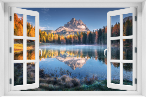 Fototapeta Naklejka Na Ścianę Okno 3D - Lake with reflection of mountains at sunrise in autumn in Dolomites, Italy. Landscape with Antorno lake, blue fog over the water, trees with orange leaves and high rocks in fall. Colorful forest