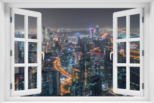 Fototapeta Naklejka Na Ścianę Okno 3D - Panoramic aerial view of business bay towers in Dubai night timelapse.