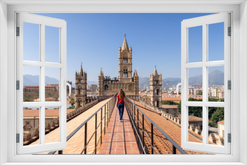 Fototapeta Naklejka Na Ścianę Okno 3D - Woman tourist visitor walking on the rooftop catwalk of the Palermo Cathedral or Cattedrale di Palermo with bell towers in the background on a nice sunny afternoon in Palermo, Sicily.