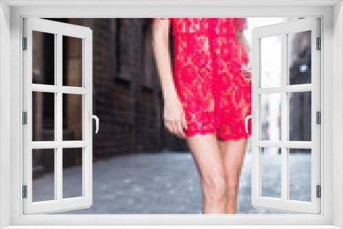 portrait of sexy young woman in red dress walking in the old city