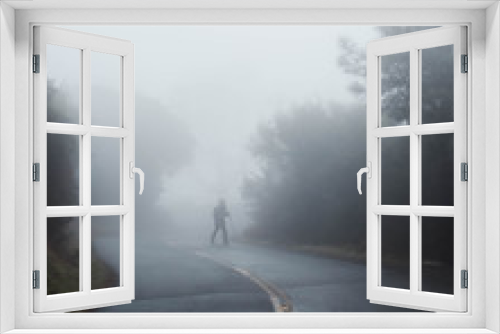 Fototapeta Naklejka Na Ścianę Okno 3D - Man hiking through dense cold fog