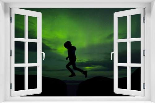 Fototapeta Naklejka Na Ścianę Okno 3D - Sillhouette of preschool child, jumping over gap on aurora borealis sky background