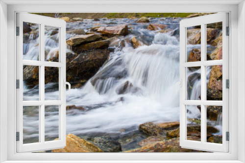 Fototapeta Naklejka Na Ścianę Okno 3D - Long exposure picture of a small cold waterfalls through boulders in Snowdonia, Wales
