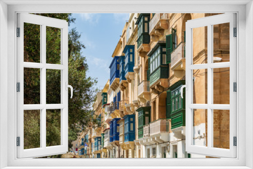 Fototapeta Naklejka Na Ścianę Okno 3D - Residential house facade with traditional Maltese multicolored enclosed wooden balconies in Valletta, Malta, in summer day. Authentic Maltese urban scene.