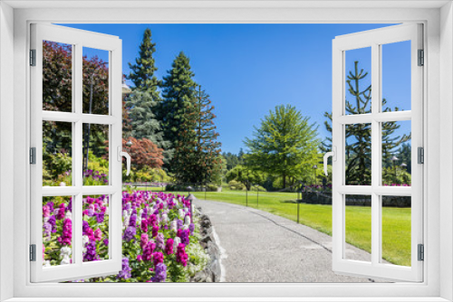 Fototapeta Naklejka Na Ścianę Okno 3D - Butchart Gardens at Victoria Island, Canada in summer.  View of the walkway with flowers and trees of the historic garden.