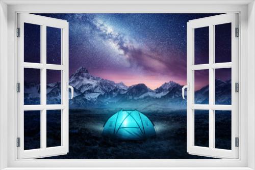 Fototapeta Naklejka Na Ścianę Okno 3D - Camping in the mountains under the stars. A tent pitched up and glowing under the milky way. Photo composite.