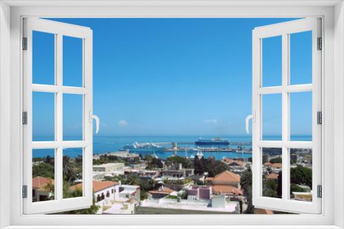 Fototapeta Naklejka Na Ścianę Okno 3D - a panoramic view of rhodes town with buildings of the city and old walls around the harbor with ships and boats next to a blue summer sea