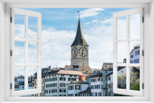 Fototapeta Naklejka Na Ścianę Okno 3D - View of the historic center of Zurich at the bank of Limmat River, with beautiful house rooftops in spring, and St. Peter Pfarrhaus  Church clock tower