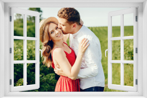 Couple in a field. Girl in a red dress. Man in a white shirt