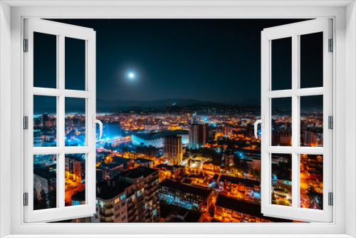 Fototapeta Naklejka Na Ścianę Okno 3D - Panorama of a luminous night city illuminated by a bright moon