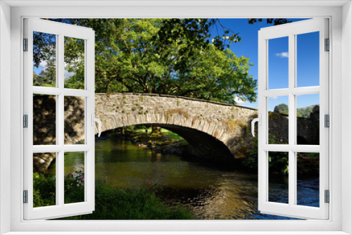 Fototapeta Naklejka Na Ścianę Okno 3D - Stone arch Pelter Bridge in evening sun over the River Rothay at Rydal Cumbria Lake District National Park England