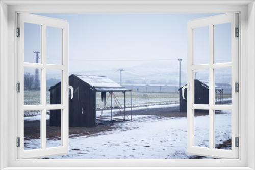 Fototapeta Naklejka Na Ścianę Okno 3D - depressing scenery. countryside with wood huts on winter day