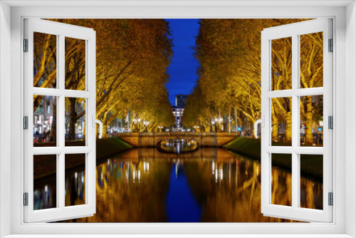 Fototapeta Naklejka Na Ścianę Okno 3D - Night view over canal and beautiful waterside area at Königsallee, famous shopping street, and background of Girardet-Brücke in Düsseldorf, Germany.
