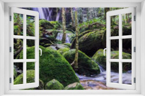 Fototapeta Naklejka Na Ścianę Okno 3D - Tham yai waterfall, a beautiful waterfall in a forest filled with green trees at Phu Kradung National Park in the rainy season, which is famous tourist destination in Thailand.
