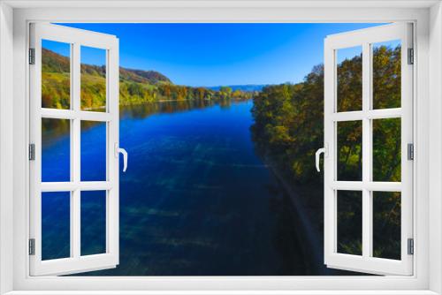 Fototapeta Naklejka Na Ścianę Okno 3D - The river Rhine, only a few hundred meters young, after leaving Lake Constance. Autumn. Near the Swiss town Stein am Rhein. View from the car bridge to the west, the road leads to the Rhine Falls.