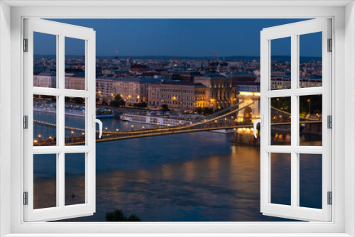 Fototapeta Naklejka Na Ścianę Okno 3D - Panorama of Budapest along the Danube River featuring the Chain Bridge and Hungarian Parliament Building at blue hour. 