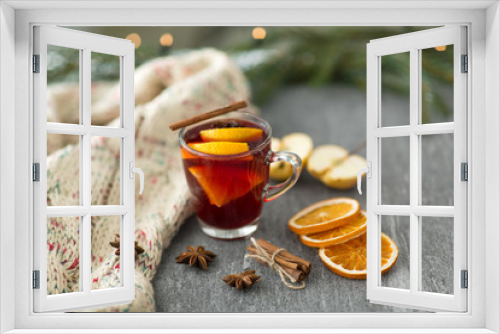 Fototapeta Naklejka Na Ścianę Okno 3D - christmas and seasonal treats concept - glass of hot mulled wine with dry orange slicess and cinnamon, star anise, knitted scarf and apples on grey stone surface