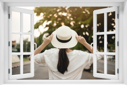 Fototapeta Naklejka Na Ścianę Okno 3D - Asian women travel for a summer vacation in Thailand. She has a hat and grabs her hat. In the refreshing concept