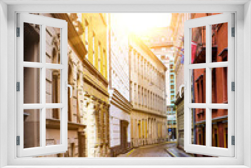 Fototapeta Naklejka Na Ścianę Okno 3D - Tight street with classic paving stones and architecture in Budapest, Hungary on sunset after a short spring rainy day. Sunny background travel concept image for flyer, brochure, website, banner etc. 