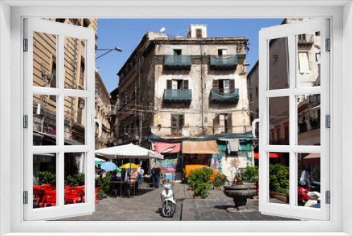 Fototapeta Naklejka Na Ścianę Okno 3D - Palermo, Italy, September 19, 2019: Square with a fountain, a parked motorbike, plants and shops around with awnings and facades of buildings in poor condition