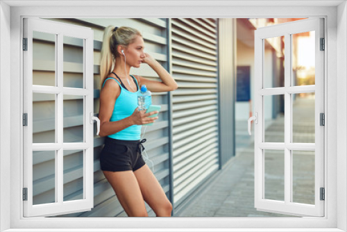 Modern sportswoman making pause after jogging in the urban area.