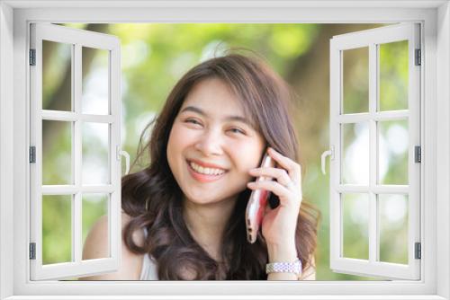 Asian women talking cellphone in city public park