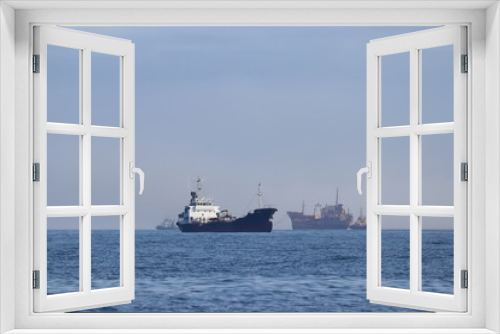 Fototapeta Naklejka Na Ścianę Okno 3D - Commercial ships moving on the route. Tugboats towing the old rusty wreck ship for ship breaking and tankermoving in oppodite direction. Calm blue sea, sunny day.