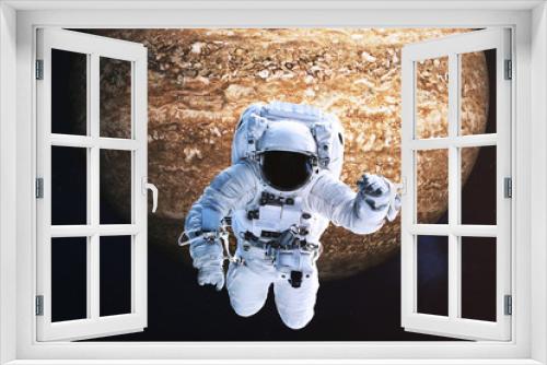 Fototapeta Naklejka Na Ścianę Okno 3D - Astronaut close to the fantastic far brown rock planet. Science fiction. Elements of the image are furnished by NASA