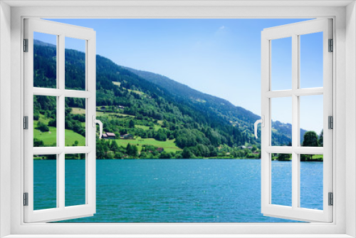Fototapeta Naklejka Na Ścianę Okno 3D - Panorama of lake Field am See in Carinthia at Austria. Landscape with pond and blue sky in spring or summer. Scenery in green Alps of Europe. Countryside with Alpine mountains. Nature with water