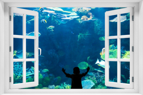 Fototapeta Naklejka Na Ścianę Okno 3D - Silhouette little boy watching fish in an aquarium , a little boy look at fish in an aquarium