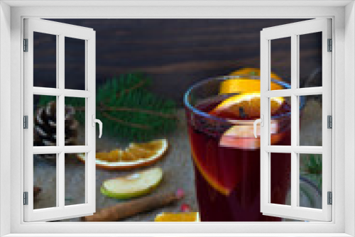 Fototapeta Naklejka Na Ścianę Okno 3D - hot drinks of winter and autumn. mulled wine with slices of orange, apple and spices, cinnamon and anise star on a wooden table with winter decorations. vertical