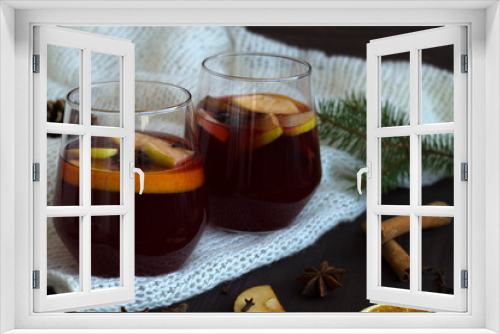 Fototapeta Naklejka Na Ścianę Okno 3D - winter collection. tasty mulled wine in a two glasses with orange and cinnamon, anise star and warm white plaid on a dark wooden background with green pine branch