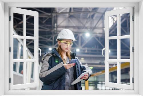 Young female technician in uniform, protective eyeglasses and helmet